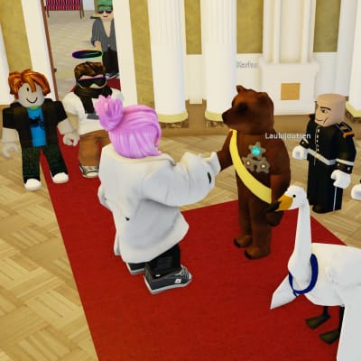 Vaaleanpunahiuksinen pelihahmo kättelee karhua pelimaailmassa Presidentin linnassa. Karhun vieressä on laulujoutsen ja takana kolme pelihahmoa.