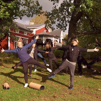 En grupp mänskor gymnastiserar i en trädgård.