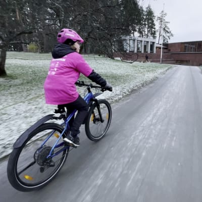 Lapsipyöräilypormestari Pinja Vienola pyöräilee Jyväskylän yliopiston kampuksen maisemissa. 