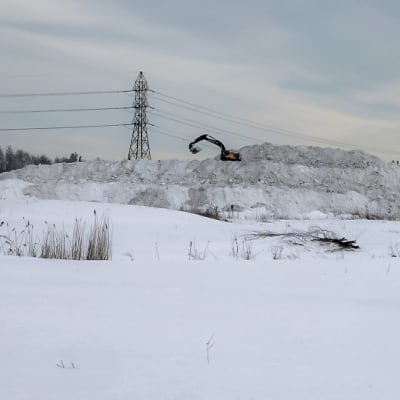 Kaivuri lumikasan päällä Oulun Oritkarissa