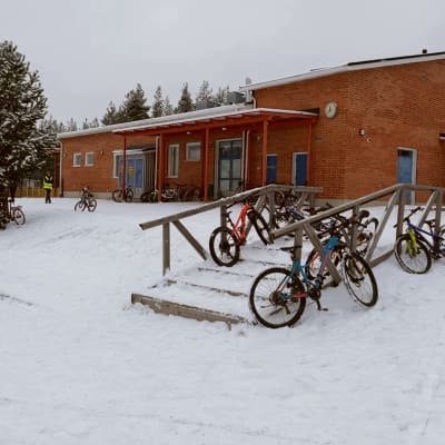 Ihmisiä liikkuu Korkalonvaaran koulurakennuksen edustalla talvisessa säässä.