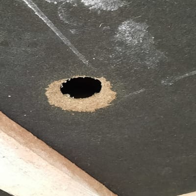 Två bilder på hål i takets isoleringsskiva.