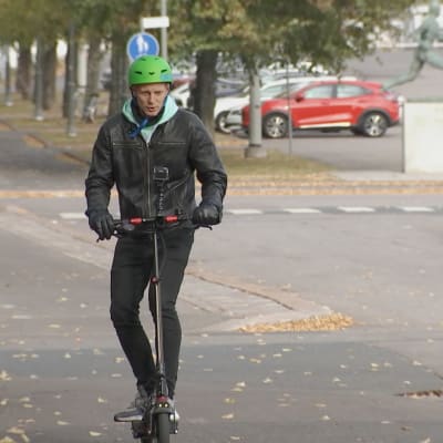 Toimittaja Tero Karhu kypärä päässä kokeilee sähköpotkulaudalla ajamista helsinkiläisellä kadulla.