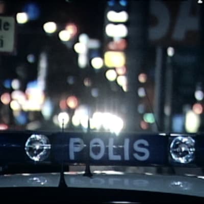 Polisbil i nattlig stad