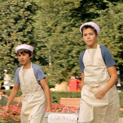 Två pojkar är utklädda till lemonadförsäljare.