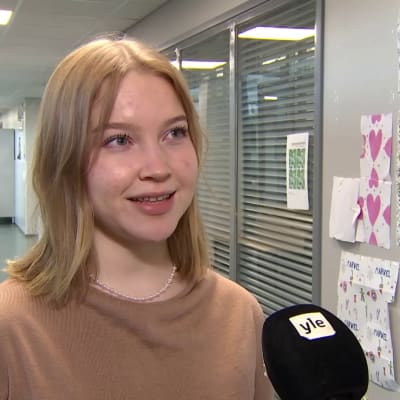 En vit, unga kvinna med kort blont hår blir intervjuad.