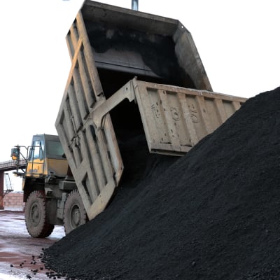 Maansiirtoauto tyhjentää kivihiililastia satamalaiturille