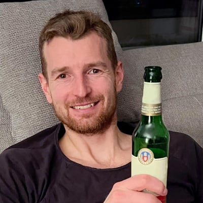 Lukas Hradecky sohvalla olutpullo kädessään.