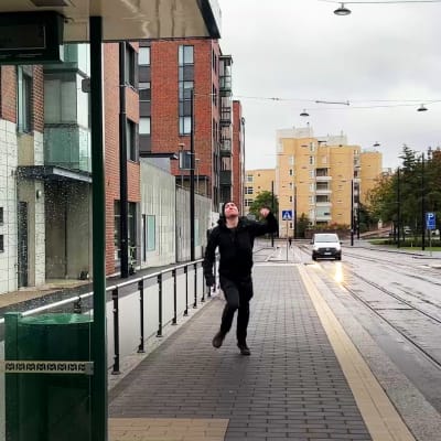 En man springer efter bussen som redan har hunnit lämna hållplatsen.