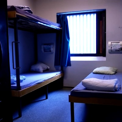 En vanlig säng och en våningssäng i en resecell i ett fängelse.