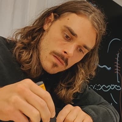 Oscar Hagen tecknar med en svart tusch