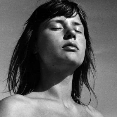Nuori nainen (näyttelijä Harriet Andersson) silmät kiinni auringossa. Kuva elokuvasta Kesä Monikan kanssa.