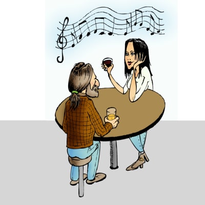 Man och kvinna sitter vid ett bord och lyssnar på musik