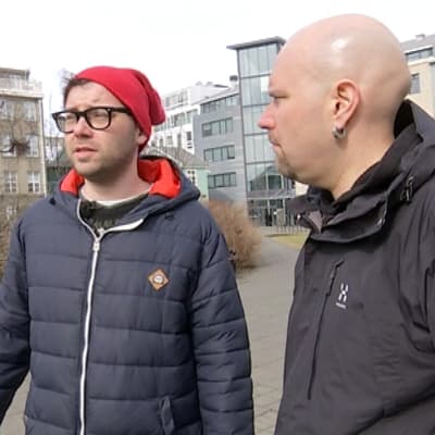 Sarjakuvataiteilija Hugleikur Dagsson ja toimittaja Totti Toivonen keskustelevat Islannin parlamenttitalon edessä olevassa puistossa.