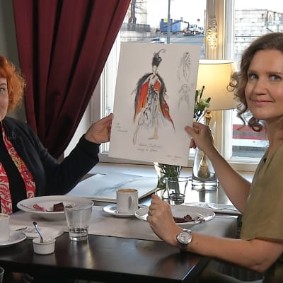 Erika Turunen tittar på en skiss av en scendräkt för Den lilla sjöjungfrun tillsammans med Pia-Maria Lehtola