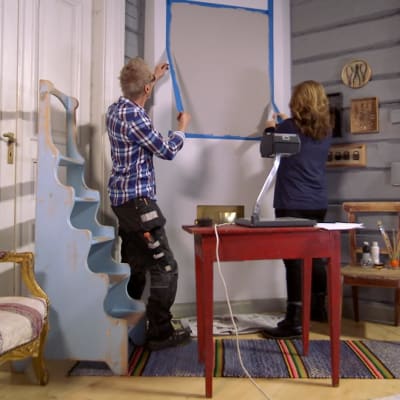 Jim Björni och Camilla Forsén-Ström tar bort målartejp från vägg