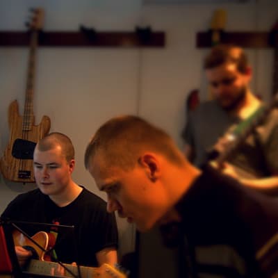 Tre killar spelar gitarr