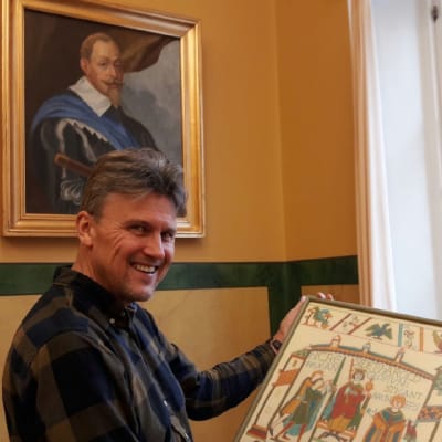 Historielektor Karl-David Långbacka och en kopia av Bayeuxtapeten