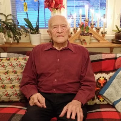 Krigsveteranen Levi Backholm sitter på sin soffa hemma i Sundom.