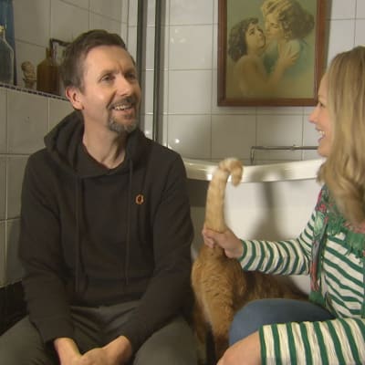 En man och en kvinna och en katt i ett badrum