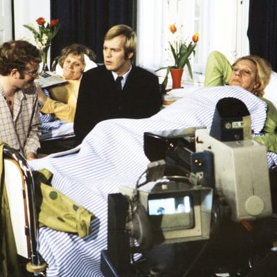 Neil Hardwick henkilöohjaa Ilmari Saarelaista ja Sylvi Salosta sairaalakohtauksessa tv-kameran edessä. Taustalla Anja Räsänen.