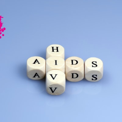 tärningar med bokstäver på, placerade så att orden hiv och aids är skrivna på en lila bakgrund