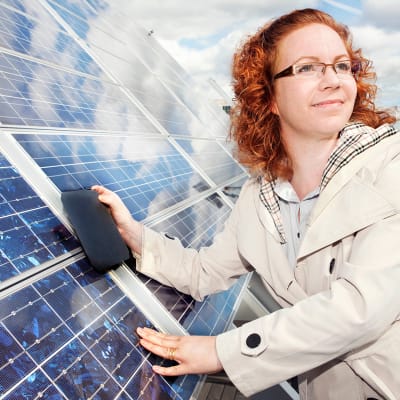 Professor Hele Savin lutar sig mot solpanel.