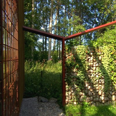Raudasta ja kivestä rakennettu aita Strömsö puutarhassa