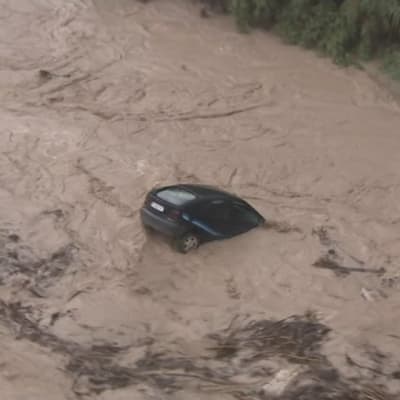 En bil drivs med vattenmassor i närheten av Valencia i Spanien där kraftiga regn orsakat omfattande översvämningar.