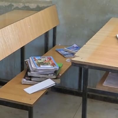 Tom skolklass. Läroböcker syns vid en pulpet.