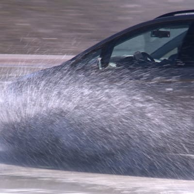 Auto ajaa veteen. Vesi roiskuu.