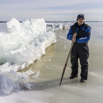 En fiskare står vid en isvall på sjön Päijänne vintern 2021.