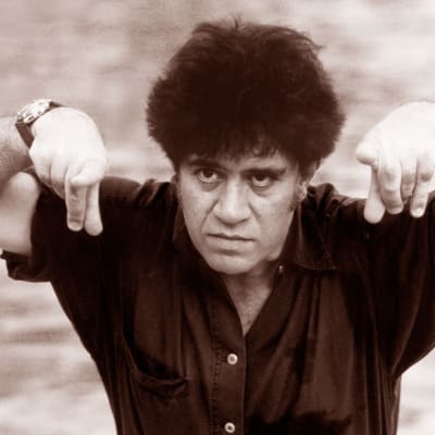 Elokuvaohjaaja Pedro Almodóvar osoittaa sormillaan kohti kameraa hieman kuin härkä sarvillaan.