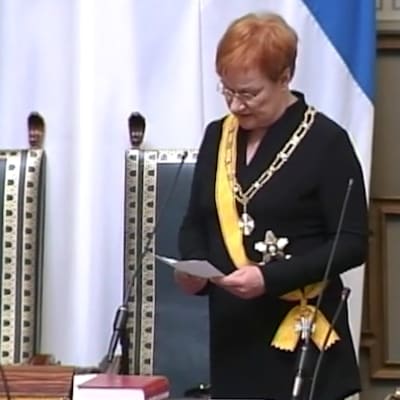 Presidentti Tarja Halonen virkaanastujaisissaan eduskunnassa, lukee paperista mikrofonin ääressä.