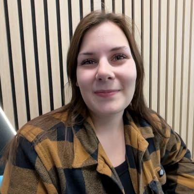 Opiskelija Essi Joensuu istuu sohvalla Lapin yliopiston aulassa.