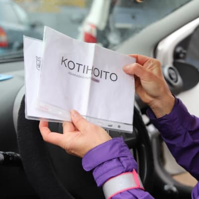 Kotihoitaja Raija Riikonen esittelee pysäköintilappua. LÄHIKUVA