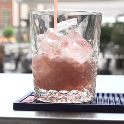 En alkoholfri, rosa drink hälls i ett glas. 
