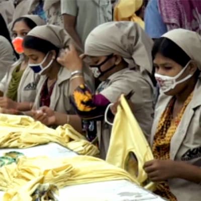 Naiset tekevät paitoja tehtaassa Bangladeshissa.