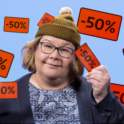 Maija Salminen poseeraa alennuslappujen keskellä.