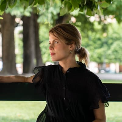 Annastiina Heikkilä istuu puiston penkillä 
