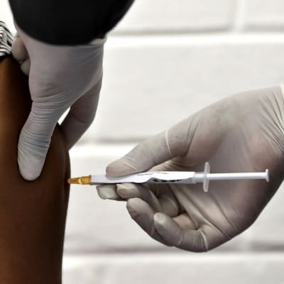 Yhtä ensimmäisistä eteläafrikkalaisista rokotekokeilijoista pistetään kliinisen tutkimuksen aikana koronaviruksen vastaista potentiaalista rokotetta vastaan ​​Baragwanathin sairaalassa Sowetossa, Etelä-Afrikassa, 24. kesäkuuta 2020.