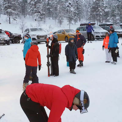 Turisteja Saariselän hiihtohissijonossa.