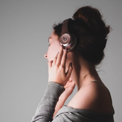 Nainen kuuntelee musiikkia kuulokkeilla.