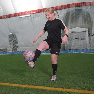 Bettina Peltoniemi tasapainoilee jalallaan jalkapalloa.