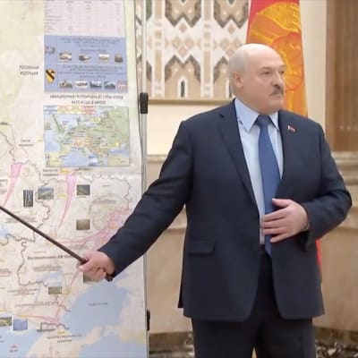 Valko-Venäjää johtava Aljaksandr Lukašenka esittelee karttaa, jossa näkyy hyökkäysnuolia Ukrainaan.