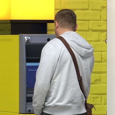 Mies nostaa rahaa käteisautomaatista Vaalimaalla
