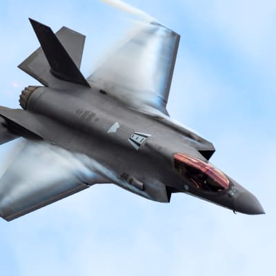 Ett F-35 jaktplan flyger diagonalt genom bilden.