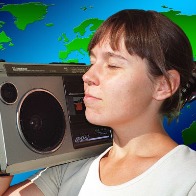 Tyttö matkaradion kanssa, taustalla maailmankartta.