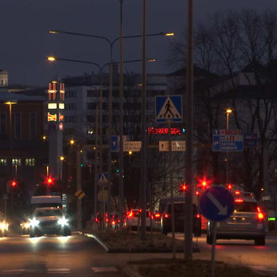 Gata i Åbo i mörker, många bilar köar vi trafikljus. 