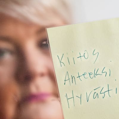 Sari Palmunen pitää käsissään Mikko-pojan jäähyväisviestiä.
